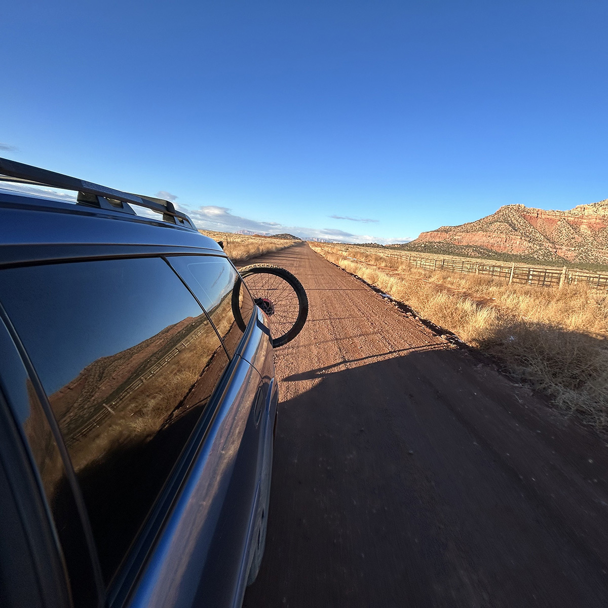 driving on a dirt road in southern utah with a specilaized mountain bike on the bike rack