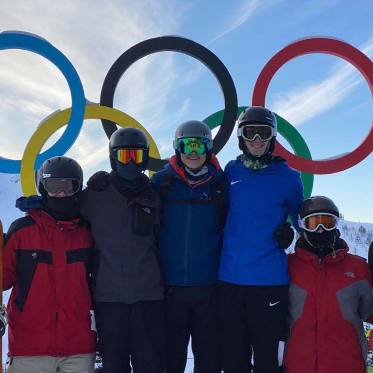 ski group taking picture with the olympic rings in canada