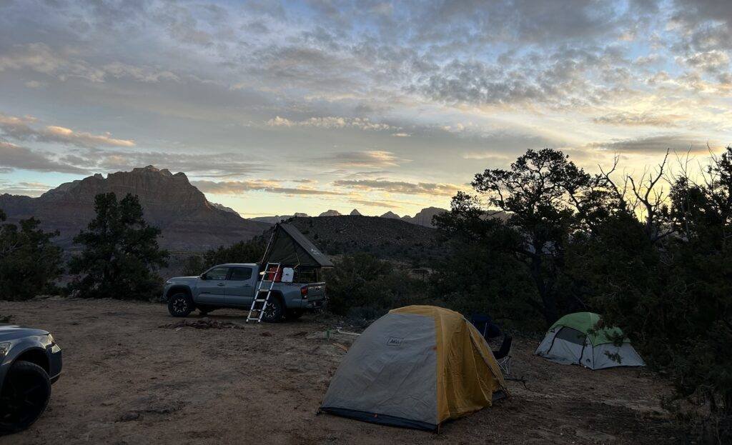 Truck and tents camped near the Wire Mesa trailhead at dusk, wide view