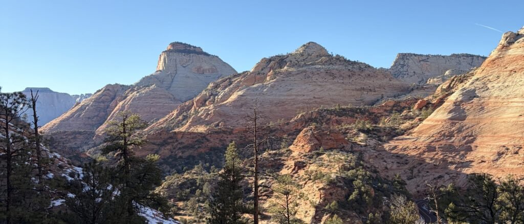 A wide view of Zion National Park's sandstone peaks from the top of the petrified dune scramble on the Triplets Trail
