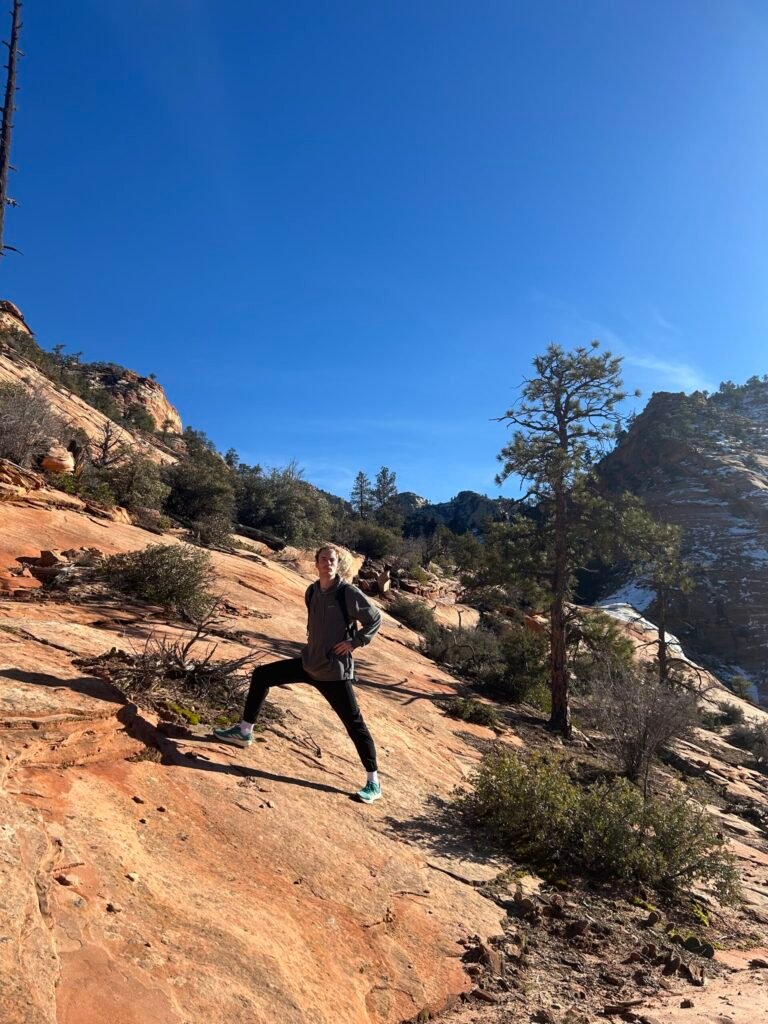 Scrambling up orange petrified sand dunes on the Triplets Trail in Zion
