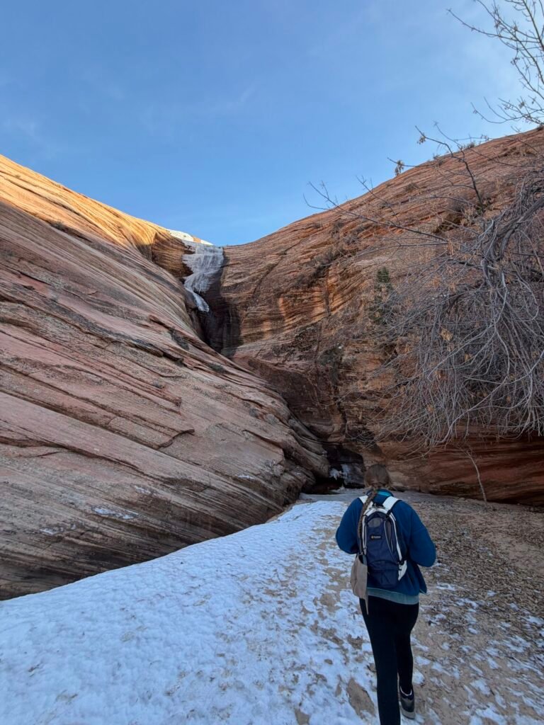 A frozen waterfall clinging to a slickrock canyon wall on the Triplets Trail in winter